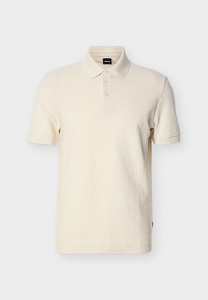 Roomkleurig poloshirt met korte mouwen, textuurrijk stof, knoopsluiting en kraag, weergegeven op een effen witte achtergrond.