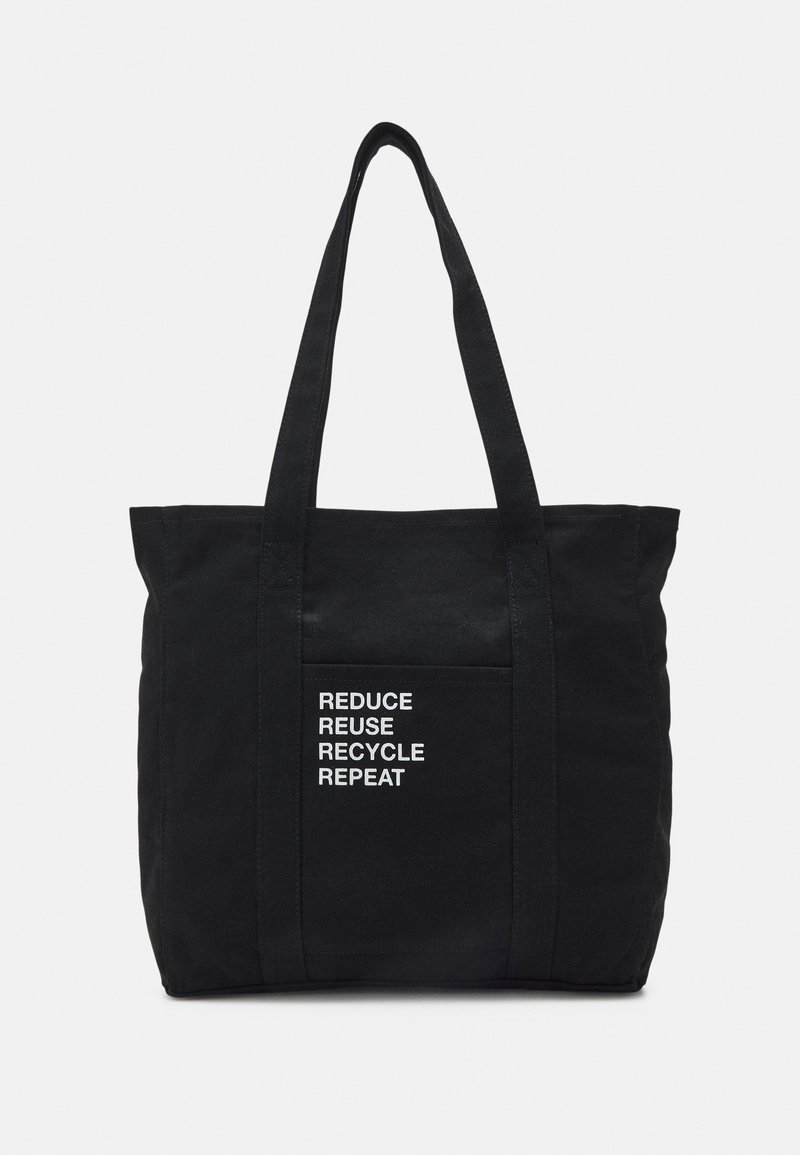 Černá plátěná taška s dvěma uchy, na přední kapse s bílým textem "REDUCE REUSE RECYCLE REPEAT". Jednoduchý, obdélníkový design.