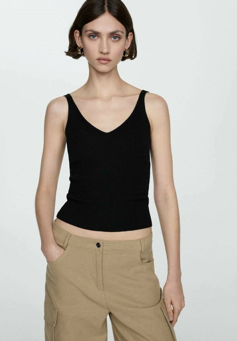 Czarna, prążkowana koszulka na ramiączkach z dekoltem w kształcie V, dopasowany krój i szerokie ramiączka, w połączeniu z beżowymi spodniami cargo o szerokich nogawkach z bocznymi kieszeniami.