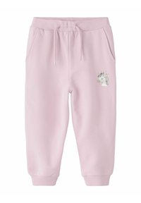 Roze trenirke izrađene od mekane tkanine s elastičnom putem, s bočnim džepovima i grafikom jednoroga na lijevoj bedri.