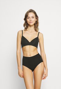 Black bra and high-waisted underwear set with a smooth texture, minimal design, and adjustable straps, showcased on a model.
