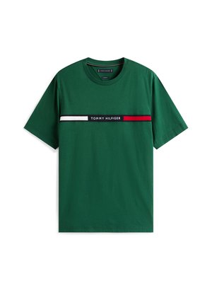 Zelena bombažna majica z vodoravno ploščo, na kateri je napis "TOMMY HILFIGER" v črni barvi, obdan z rdečimi in belimi črtami. Kratke rokave.