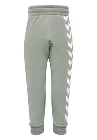 Lichtgroene sweatpants met een geribde tailleband, elastische boorden en een wit chevronpatroon langs de zijkant. Gemaakt van zachte, gestructureerde stof.