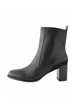 Bottine en cuir noir avec un bout pointu, texture lisse et un talon bloc cylindrique. Dotée d'une petite languette à l'arrière pour faciliter l'enfilage.