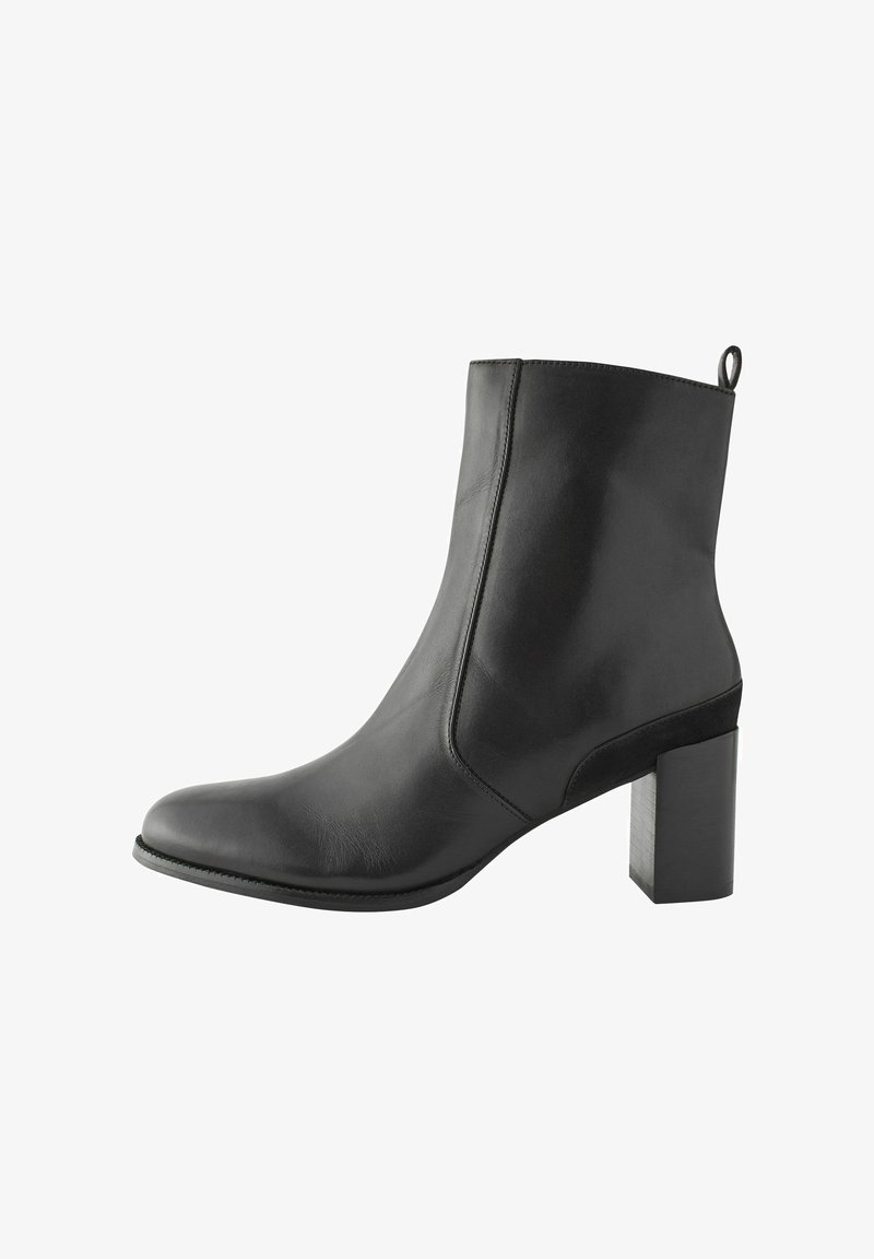 Bottine en cuir noir avec un bout pointu, texture lisse et un talon bloc cylindrique. Dotée d'une petite languette à l'arrière pour faciliter l'enfilage.