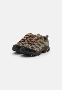Chaussures de plein air avec un mesh gris et noir, des accents orange, une semelle robuste et un système de laçage cohérent adapté à différents terrains.