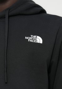 Μαύρο φούτερ με κουκούλα από μαλακό ύφασμα, με λευκό λογότυπο "THE NORTH FACE" στο αριστερό μέρος του στήθους. Διαθέτει ρυθμιζόμενη κουκούλα με κορδόνι.