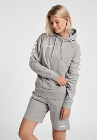 Hoodie cinza com detalhes e logo brancos, apresentando um capuz com cordão e mangas raglan, combinado com calções cinzentos a condizer.