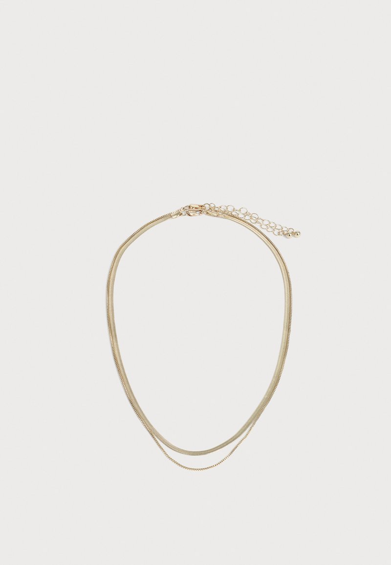 Collier doré à double rang avec une fine chaîne et une chaîne serpent plus épaisse, doté d'un fermoir réglable, sur fond blanc uni.