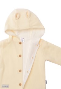 Cream-colored baby bodysuit with a ribbed texture, a hood featuring bear ears, and wooden buttons down the front. Soft inner lining.