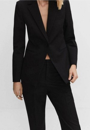 Blazer et pantalons noirs ajustés, en tissu lisse. Présente un revers cranté, une fermeture à un bouton et une coupe slim.