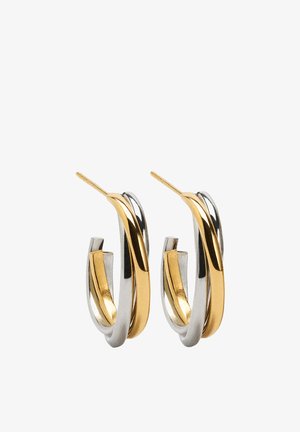 Kolczyki koła z przeplatającymi się tonami złota i srebra, o polerowanym wykończeniu. Projekt charakteryzuje się gładkimi krzywiznami i eleganckim wyglądem.