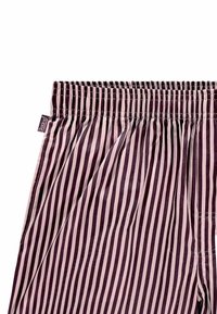 Pantaloni del pigiama a righe in un profondo bordeaux e taupe. Presentano una vita elasticizzata e un tessuto leggero e liscio con una vestibilità comoda.