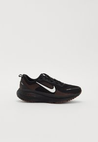 Chaussure de course Nike noire avec logo swoosh blanc et semelle texturée, vue de côté sur fond blanc uni.