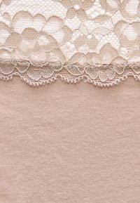 Μπεζ ύφασμα με περίτεχνο κυματιστό δαντελένιο τελείωμα που διαθέτει λουλουδένια σχέδια κατά μήκος της άκρης.