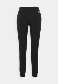 Černé tepláky vyrobené z měkké, elastické tkaniny, vybavené zúženými nohavicemi, elastickým pasem a malým logem na zadní straně.