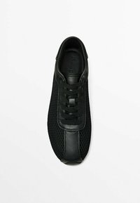 Mustat lenkkarit, joissa on verkkomateriaali ja sileät nahkaosat, pyöreä kärki ja litteät mustat nauhat turvalliseen istuvuuteen.