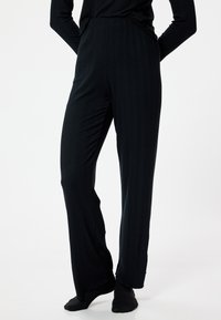 Zwarte ribbel loungebroeken met een recht model, gemaakt van een zachte, textuurstof en voorzien van een elastische tailleband voor comfort.