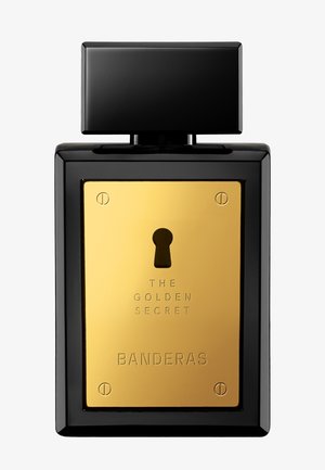 Flacon de parfum rectangulaire noir avec une grande plaque avant dorée comportant un trou de serrure et un texte gravé « The Golden Secret Banderas ».