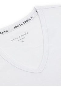 Biała bawełniana koszulka z głębokim dekoltem w serek i płaskimi szwami. Metka z logo marki "PAKO LORENTE" w czerni znajduje się przy kołnierzyku. Rozmiar: M.