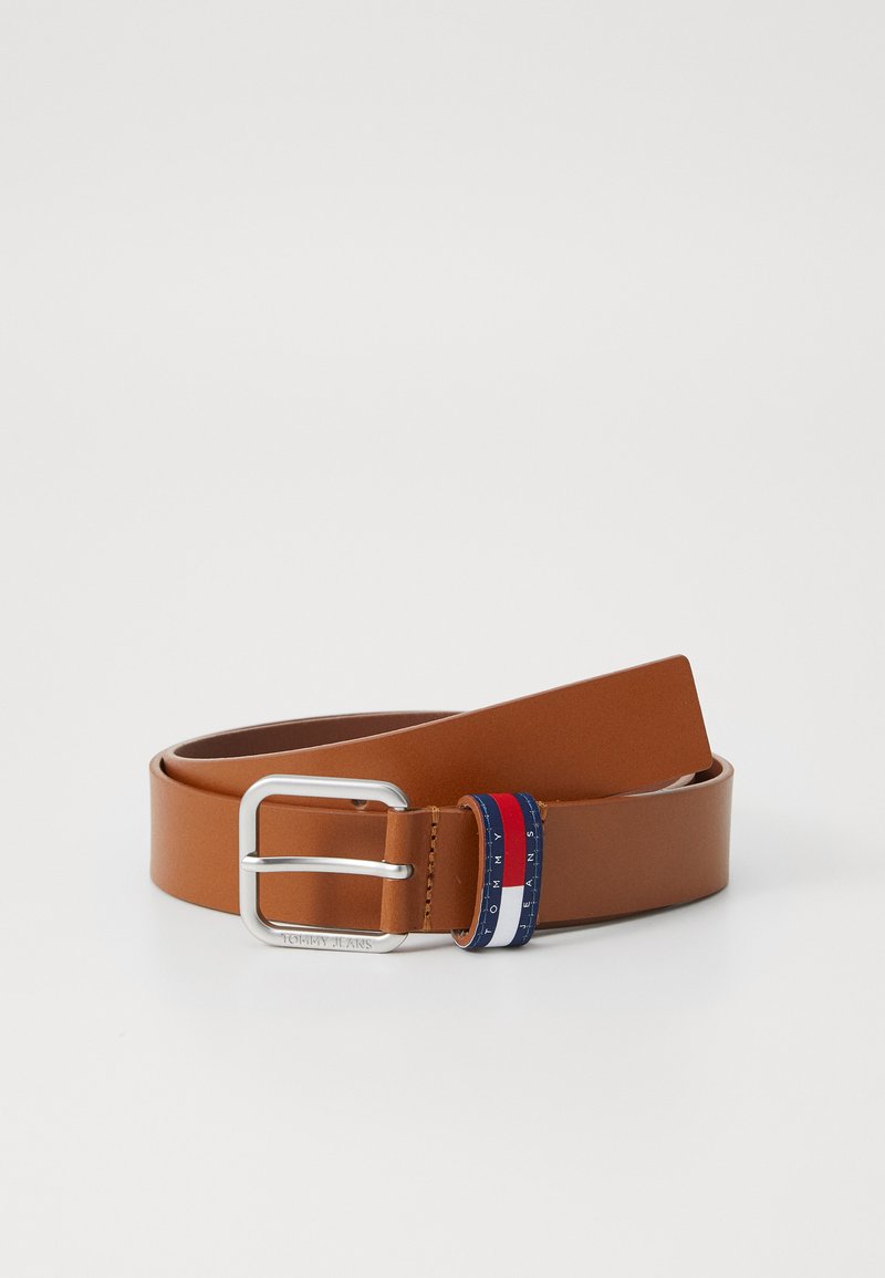 Cinturón de cuero marrón con una hebilla rectangular de plata y un acento decorativo a rayas en rojo, blanco y azul cerca de la hebilla.