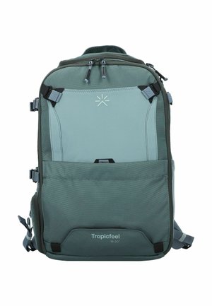 Green backpack with a two-tone design, features adjustable straps, multiple compartments, and logo in the center. Made of durable fabric.