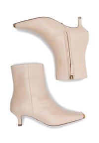 Bežīgas ādas potīšu kurpes ar smailu purngalu, zemu kaķa papēdi, sānu rāvējslēdzējiem un gludu tekstūru; zelta krāsas purngala detaļa.