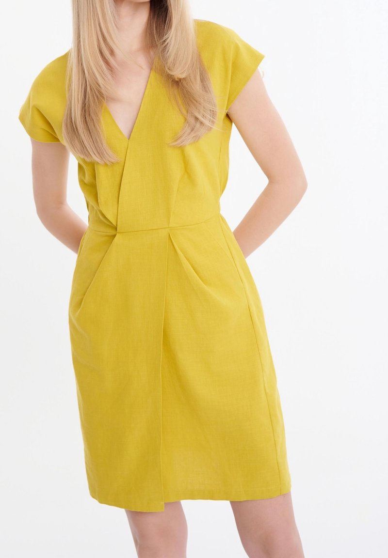 Lyhythihainen, V-pääntie mekko kirkkaankeltaisesta kankaasta. Sisältää poimutuksia vyötäröllä ja suoran leikkauksen, jossa on sileä pinta eikä näkyviä kuvioita.
