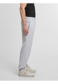 Lichtgrijze sweatpants van zachte stof, met een elastische tailleband, zijzakken en een recht model. Draagt met lichte sneakers.