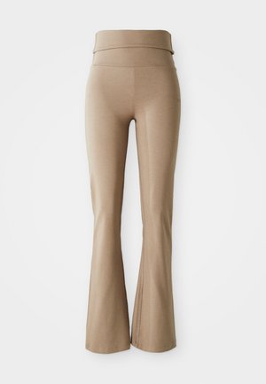 Beige vide leggings laget av elastisk stoff; har en bred, sammenleggbar midjebånd og subtile sømdetaljer. Glatt tekstur, tettsittende design.
