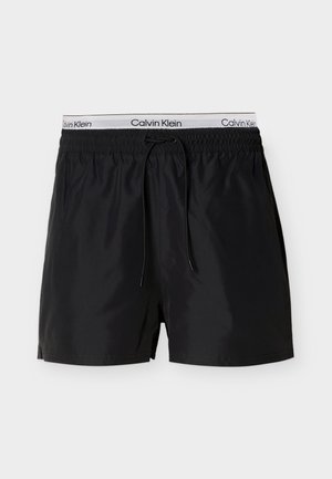 Pantaloncini da bagno neri con vita elastica e logo "Calvin Klein" bianco. Realizzati in materiale leggero, con coulisse per la vestibilità.