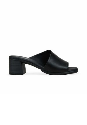 Sandalia mule negra con punta abierta, parte superior de cuero ancho y tacón bajo de bloque sobre fondo blanco.
