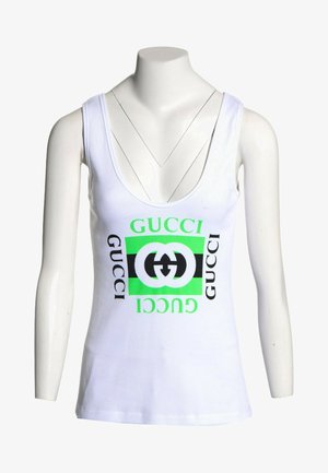 Biały bezrękawnik z prążkowanego materiału z zielono-czarnym logo Gucci nadrukowanym na środku, prezentowany na manekinie bez głowy.