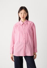 Pink striped button-up shirt with a collar, long sleeves, a chest pocket, and subtle metallic accents throughout the fabric.