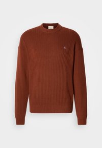 Roodbruine geribde trui met een ronde hals, voorzien van een klein logo op de borst en een relaxte pasvorm. Gemaakt van een textiel met een structuur.