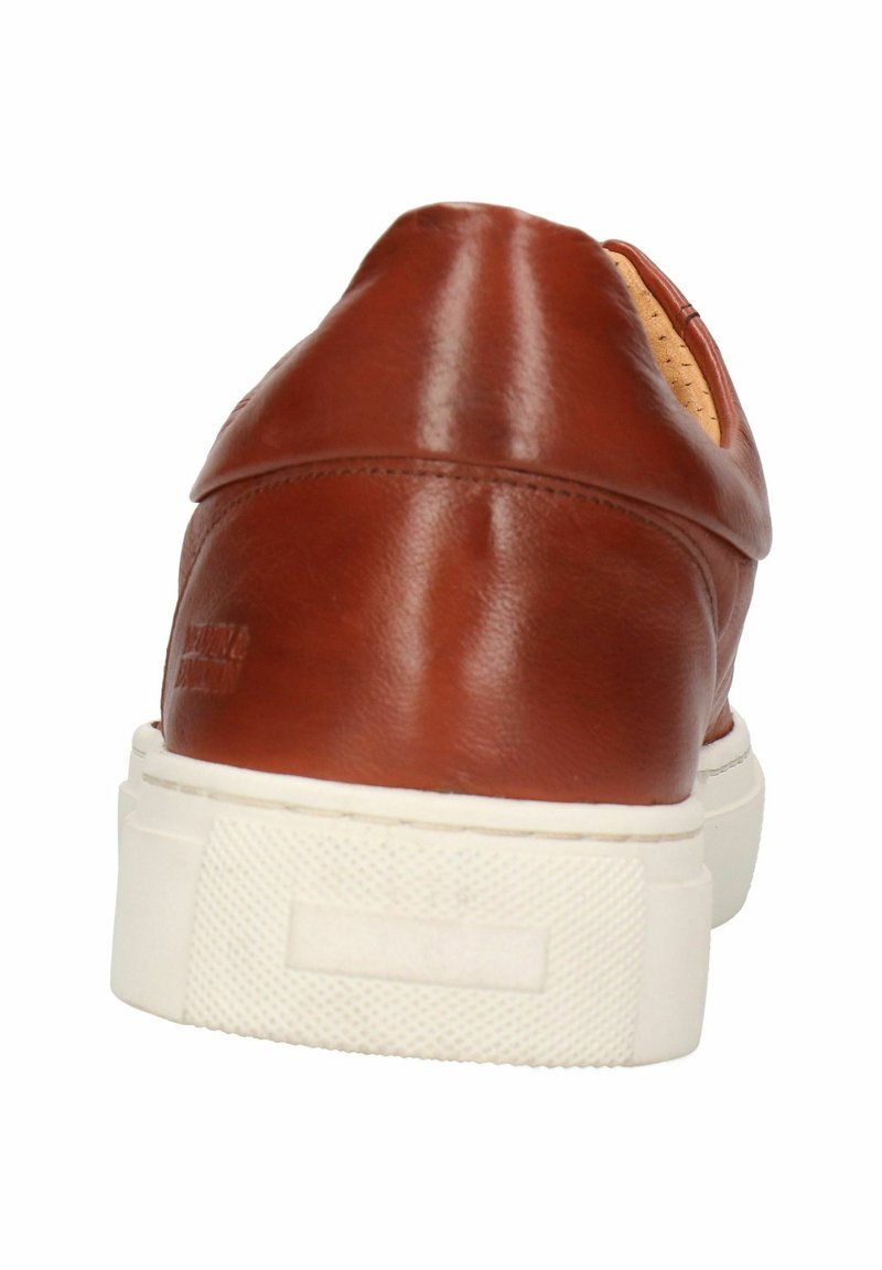 Chaussure en cuir marron avec un talon arrondi, semelle en caoutchouc texturé blanc et minimalisme de points de couture. L'intérieur révèle une doublure beige clair.