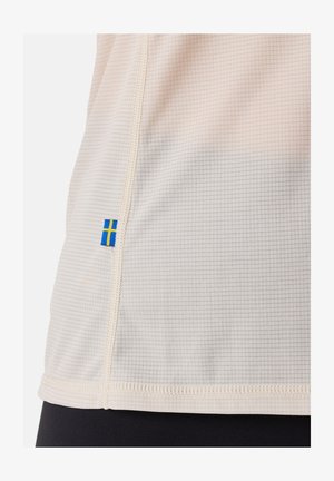 Lichtbeige sportshirt met een gridstructuur, afgebiesde naden en een klein accent van de Zweedse vlag nabij de onderzoom.