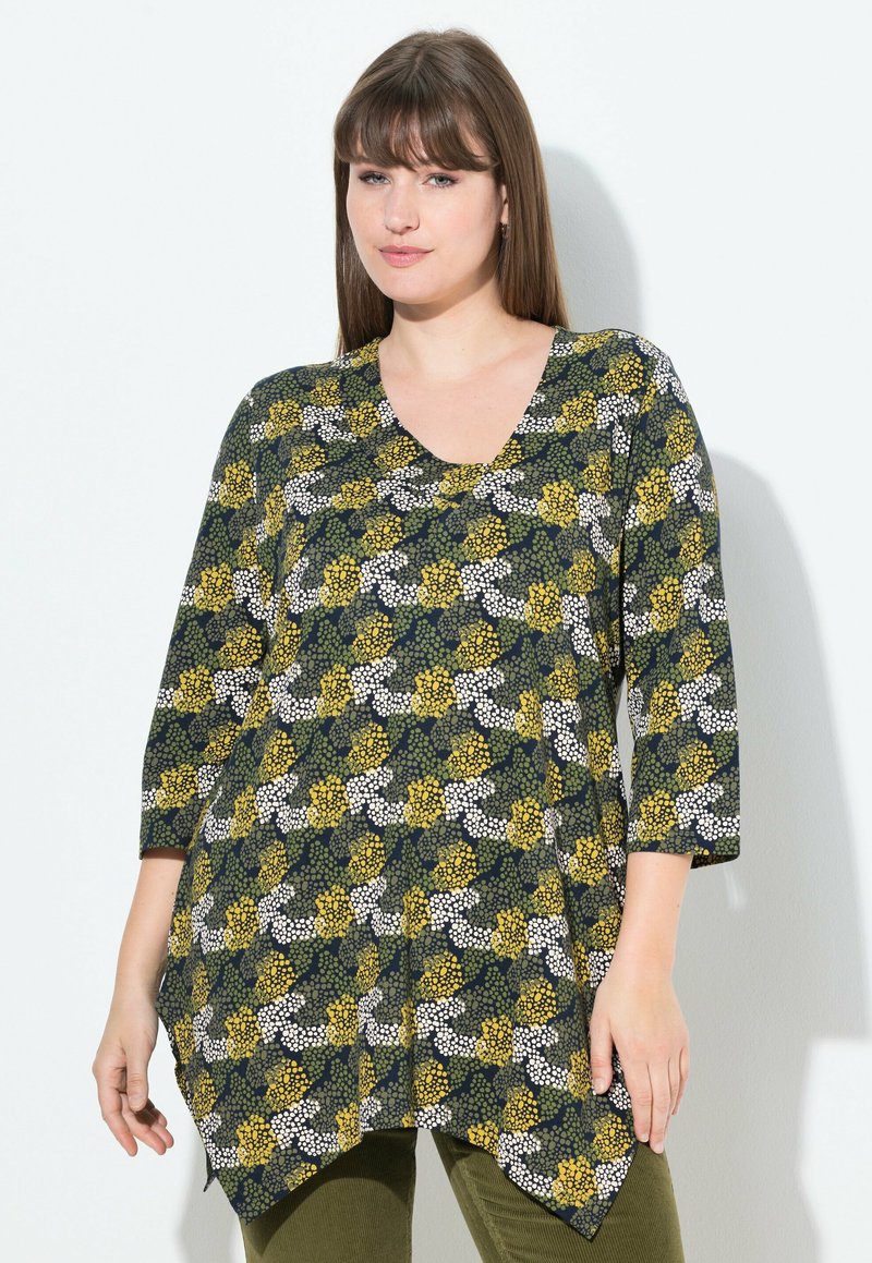 Tunic nera con stampa floreale gialla e bianca, scollatura a V e maniche a tre quarti; design fluido con orlo asimmetrico.
