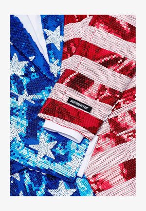 Blazers de lentejuelas en azul con estrellas blancas y rojos con rayas blancas. Ambos presentan una textura similar a la satén y el logo "SUITMEISTER" en la manga.