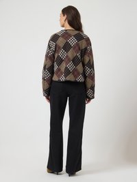 Cropped, multicolored plaid jacket with black, brown, and beige tones. Features wide sleeves and a round neckline. Paired with black wide-leg pants.