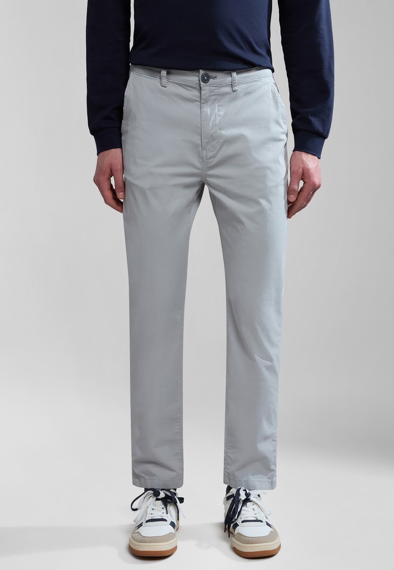 Ljust grå bomullströjor med slim fit, med knappstängning och sidofickor. Matchas med vita sneakers med marinblå detaljer.