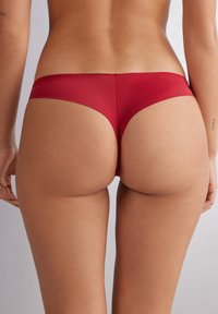 Red hipster bikini bottom with a seamless design, soft texture, and moderate coverage, showcasing a smooth and fitted silhouette.