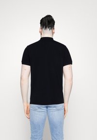 Schwarzes kurzärmliges Poloshirt mit Kragen, aus glattem Baumwollstoff. Verfügt über einen geraden Saum und gerippte Bündchen.