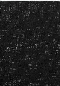 Svart texturerad tyg med ett vävt mönster som har subtila vita prickar. Materialet har ett grovt, texturerat utseende.