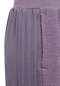 Lila klänning med en texturerad, fluffig panel på ena sidan, ribbat detaljer längs tyget och en åtsittande midja.