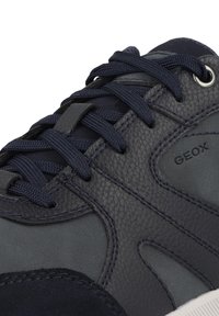 Sneaker navy realizzata in pelle testurizzata e suede, con lacci piatti, occhielli in argento e suola in gomma. Logo visibile sul lato.