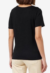 T-shirt nera a maniche corte con scollatura rotonda, realizzata in tessuto morbido. Presenta una texture liscia e un design semplice e classico.