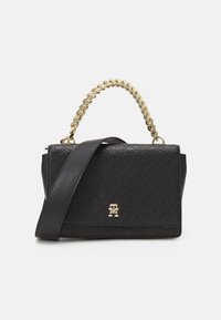 Zwarte leren handtas met een geperst geometrisch patroon, gouden ketting handvat, brede schouderband en een klein gouden logo op de voorklep.