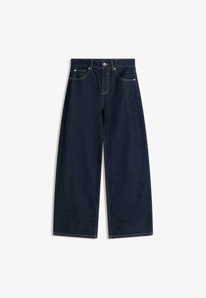 Granatowe szerokie jeansy z przodu z kieszeniami, zapięciem na guziki i widocznymi przeszyciami na białym tle.