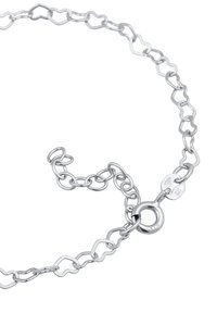 Silverkedja armband med hjärtformade länkar, som har en rund låsning och är stämplad med 925. Slät metallyta med en glänsande finish.